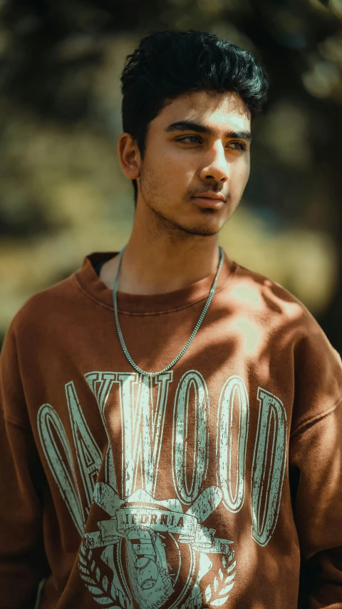 a man with a necklace around his neck standing outside