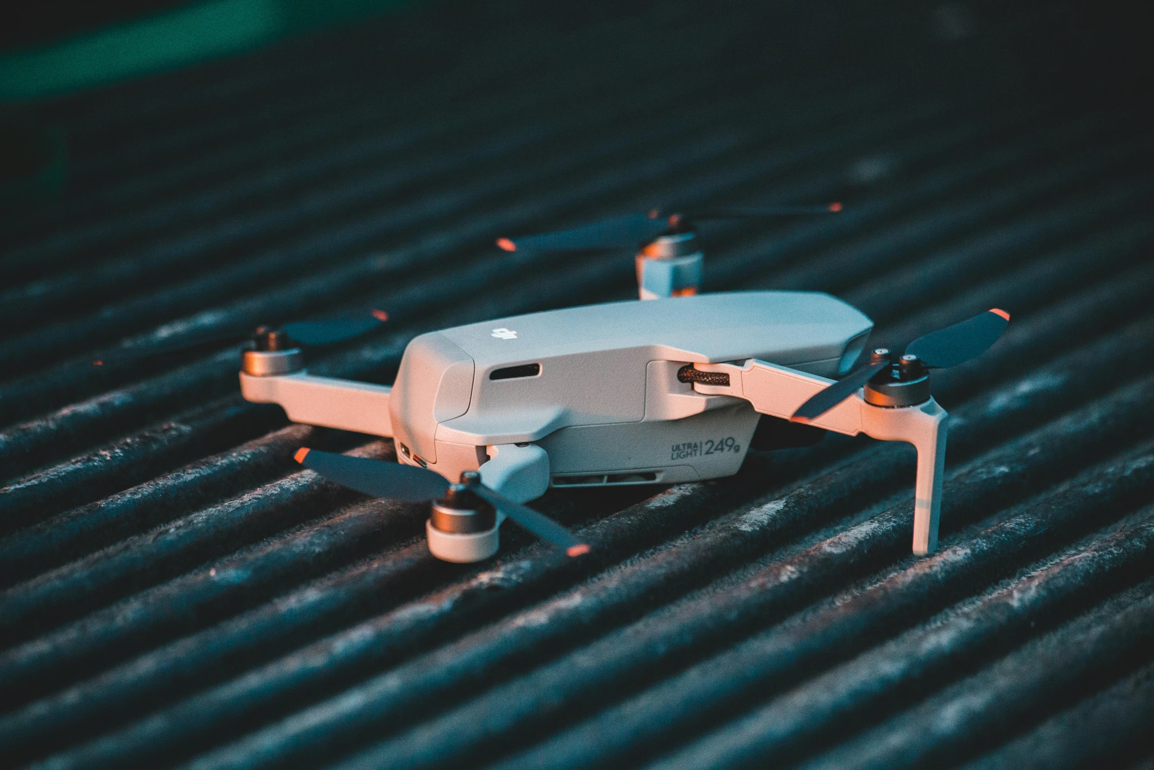 a small white drone sitting on top of a metal surface, pexels contest winner, hurufiyya, on ground, thumbnail, realistic shot, cooked