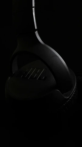 a pair of headphones sitting on top of a table, by Niels Lergaard, trending on zbrush central, black on black, ap press photo, close - up profile, -n 8