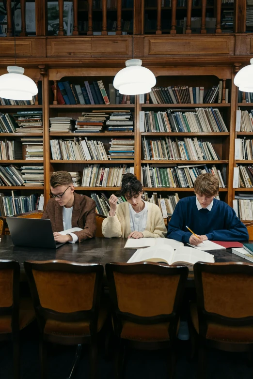 a group of people sitting at a table in a library, by Nina Hamnett, unsplash, academic art, boys, academic clothing, ignant, laptops