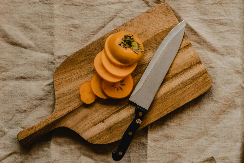 a knife sitting on top of a wooden cutting board, by Carey Morris, pexels contest winner, orange skin, fruit, manuka, moroccan