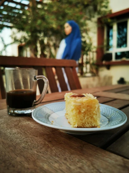 a piece of cake on a plate next to a cup of coffee, by Cafer Bater, hurufiyya, chill time. good view, ((oversaturated)), outdoor, yellow