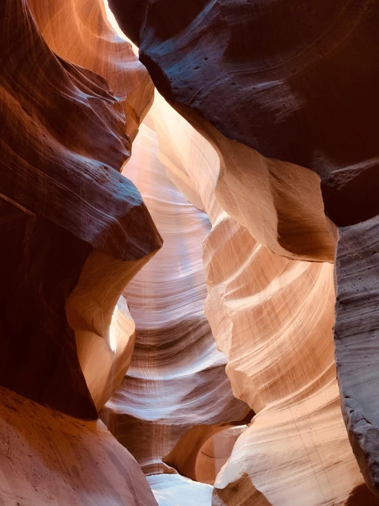 a narrow slot in the side of a canyon, by Greg Rutkowski, pexels contest winner, art nouveau, horns, 2022 photograph, light glow, wrinkled