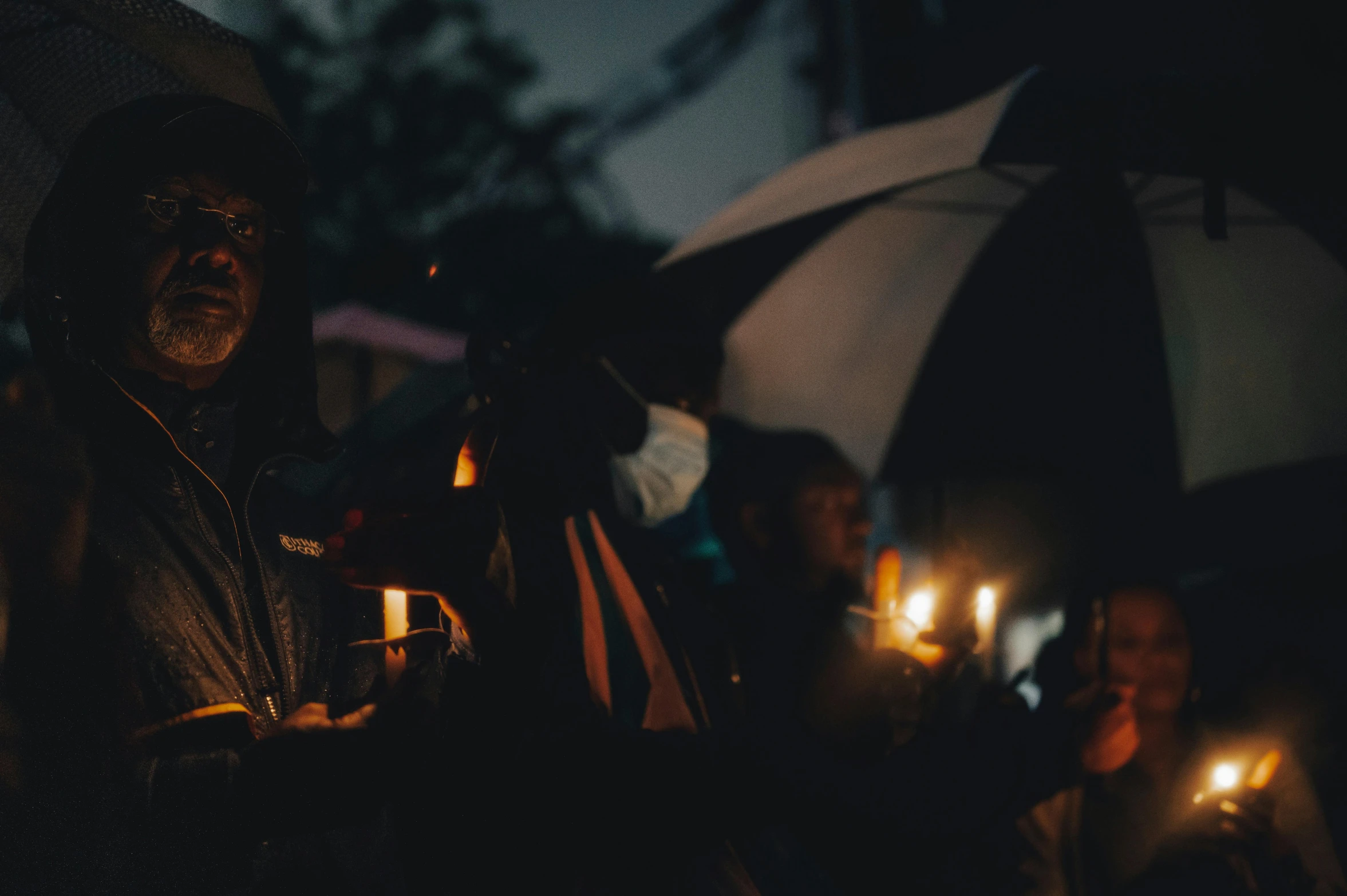 a group of people holding candles and umbrellas, photo of a black woman, mourning, shot on canon eos r5, cinematic photo