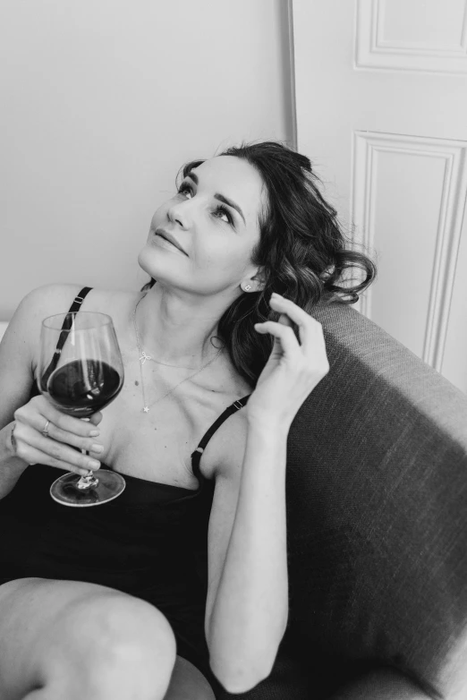 woman sitting on couch and holding a glass of wine