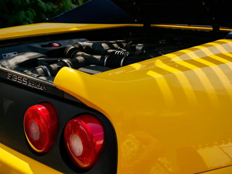 a close up of a yellow car with its hood up