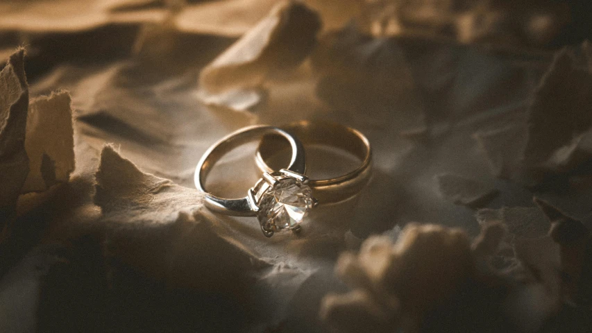 a couple of wedding rings sitting on top of a piece of paper