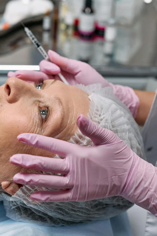a woman getting an injection from a doctor, a photo, shutterstock, renaissance, square facial structure, pink, video still, grey