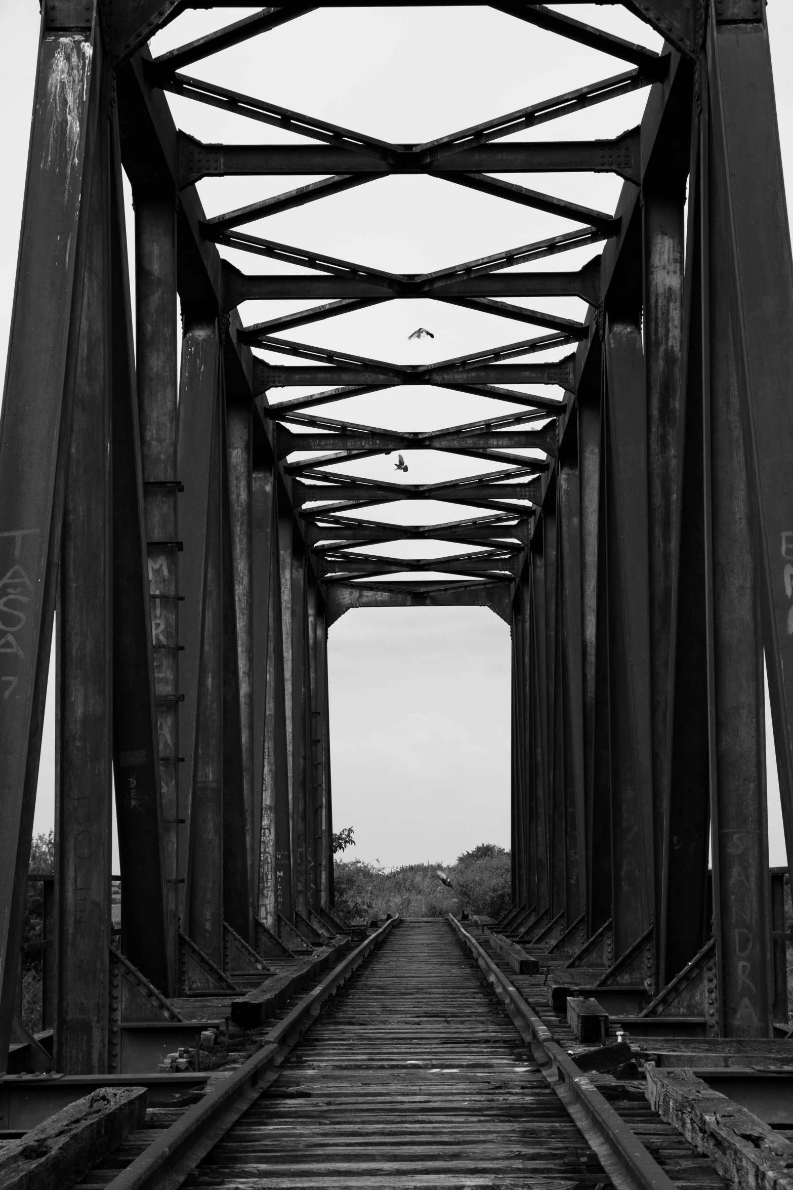 a black and white photo of a train track, by Altichiero, hanging bridge!!, rusted, ponte 2 5 de abril, in 2 0 1 8