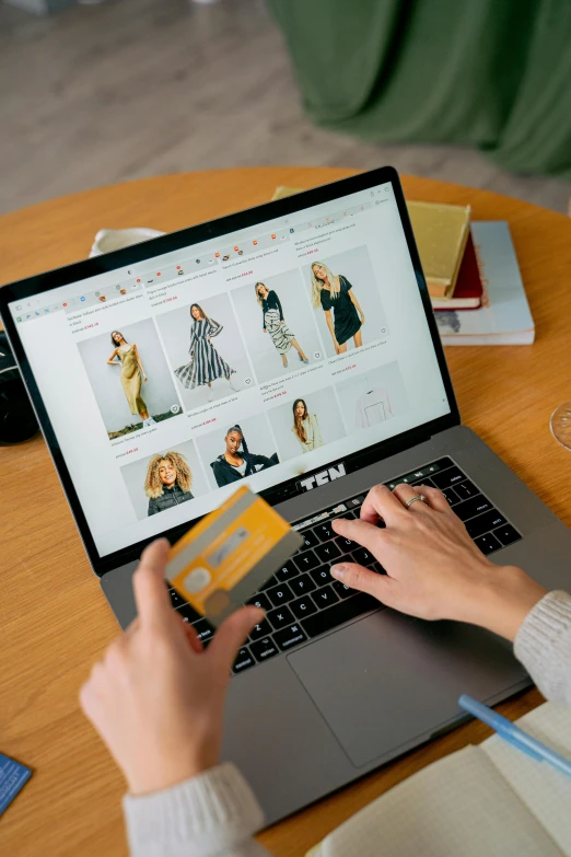 a woman sitting at a table with a laptop and a credit card, a digital rendering, trending on pexels, elaborate clothing, ebay listing thumbnail, lady using yellow dress, zoomed in