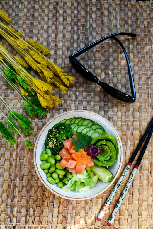 a close up of a bowl of food with chopsticks, inspired by Kanō Tan'yū, garden behind the glasses, beach setting, vibrant green, full face view