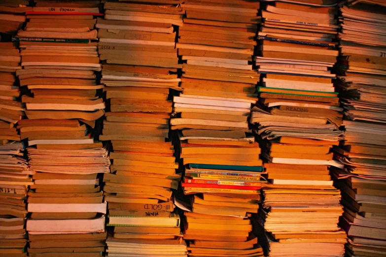 a bunch of books stacked on top of each other, an album cover, by Bernard Meninsky, unsplash, figuration libre, orange extremely coherent, piles of paperwork, taken in the late 2000s, dim lit