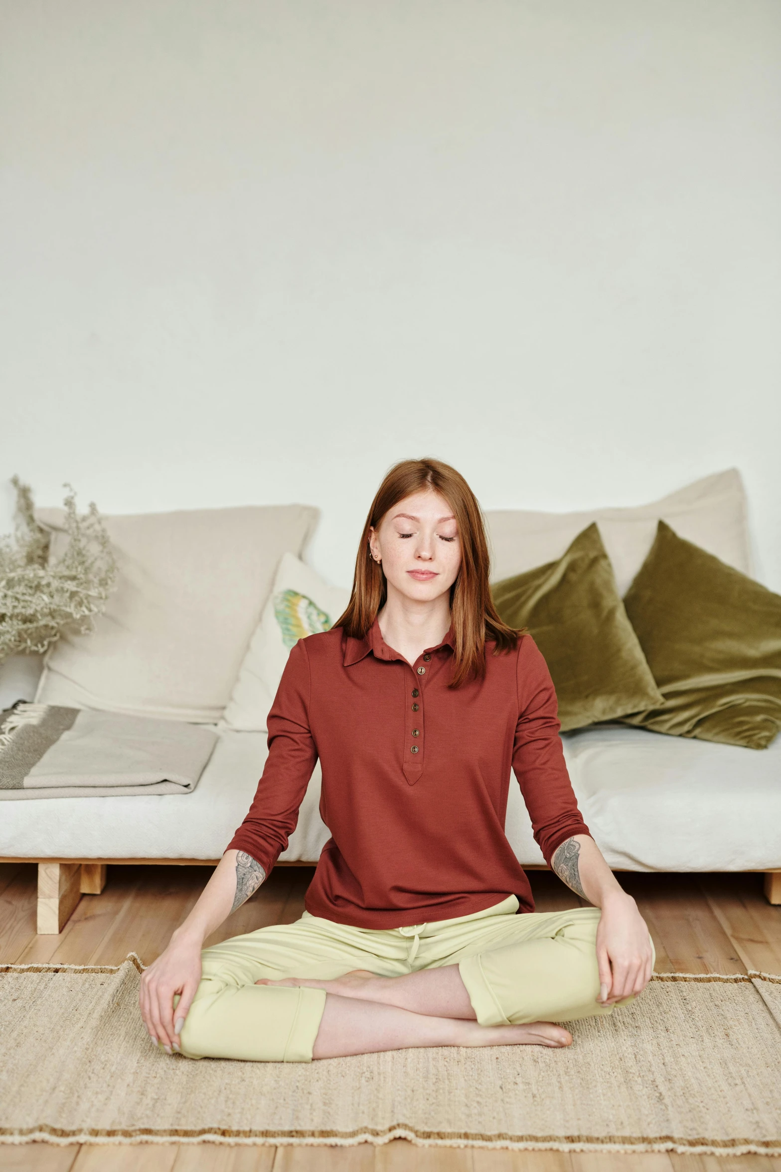 a woman sitting in a lotus position on a rug, a picture, by Anna Boch, sitting on a mocha-colored table, relaxing on a couch, promo image, plain background