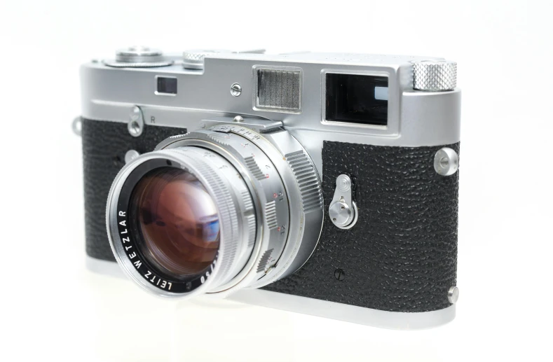 a silver and black camera on a white surface, photo 3 5 mm leica, impeccable military composure, | 28mm |, grey metal body