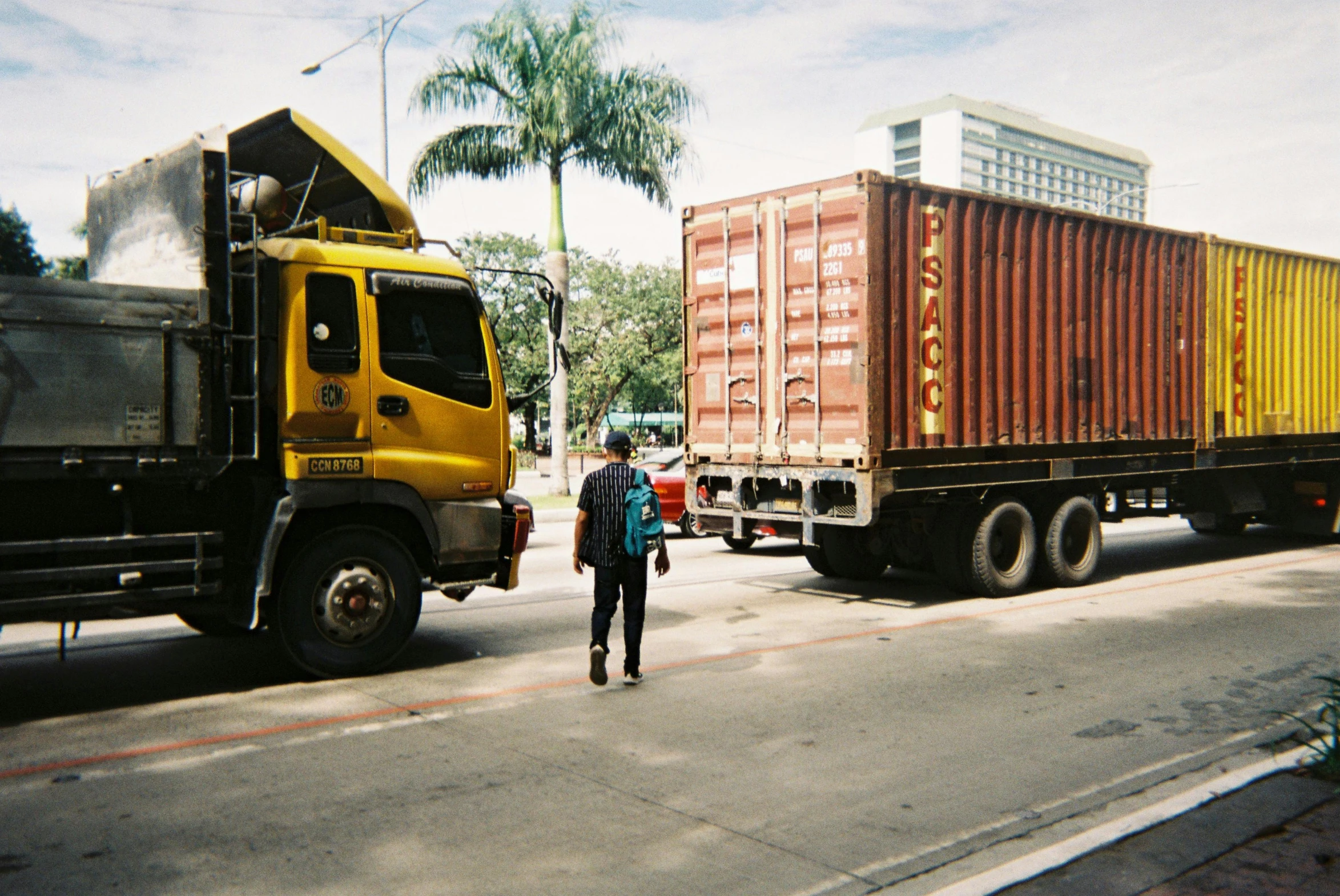 a man walking down a street next to a truck, unsplash, photorealism, malaysian, 1999 photograph, traffic accident, grain”