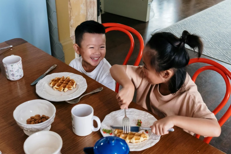 two s sitting at a table with plates of food