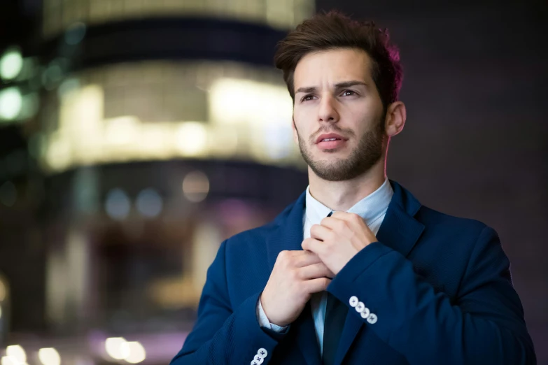 a man in a suit adjusting his tie