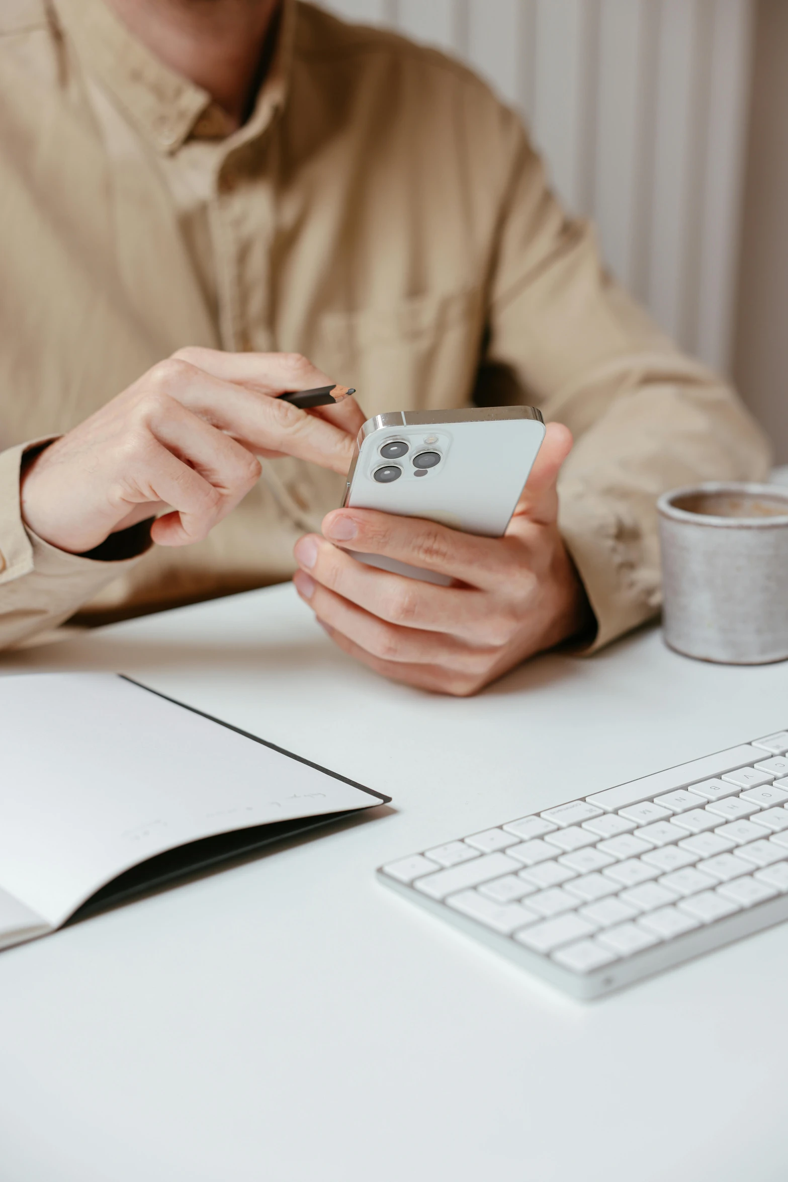 a man sitting at a desk using a cell phone, trending on pexels, minimalist logo without text, holding controller, ( 3 1, multiple stories