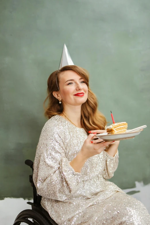 a woman sitting in a wheel chair holding a plate with a piece of cake on it, a portrait, by Julia Pishtar, shutterstock contest winner, wearing a party hat, grey and silver, 15081959 21121991 01012000 4k, scandinavian