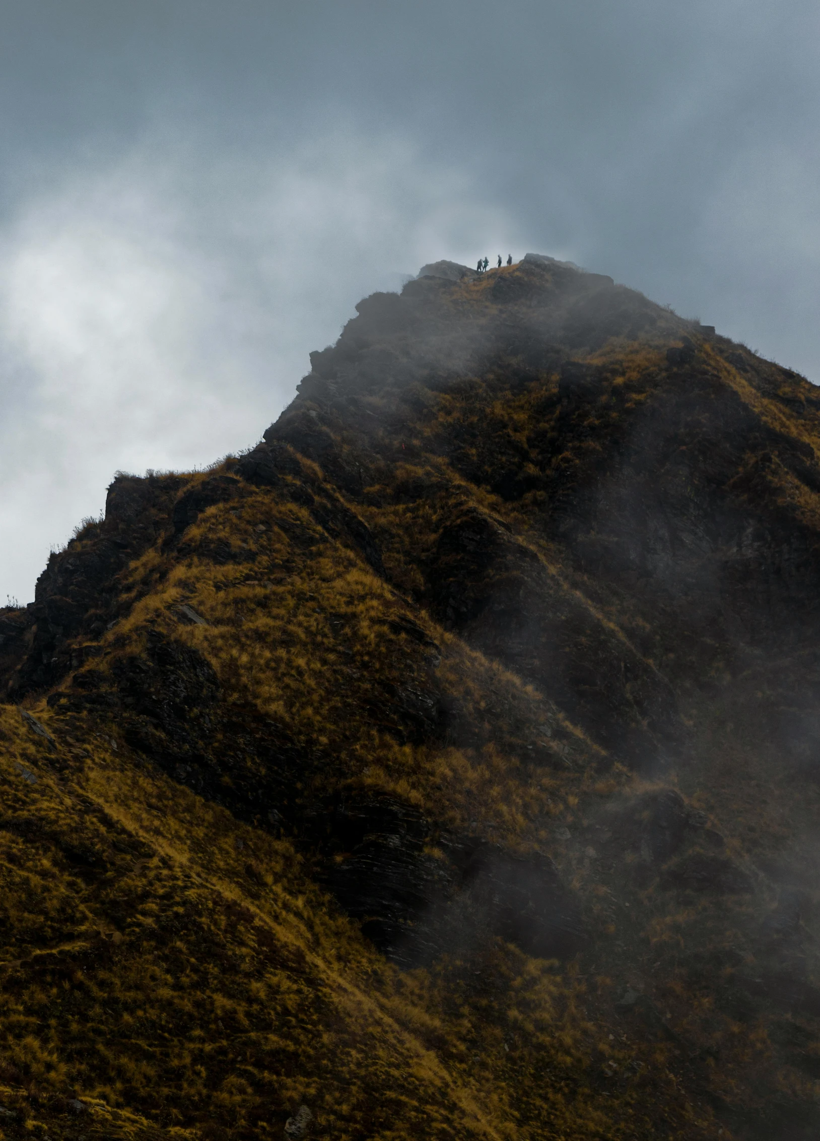 people standing on top of a mountain, surrounded by fog