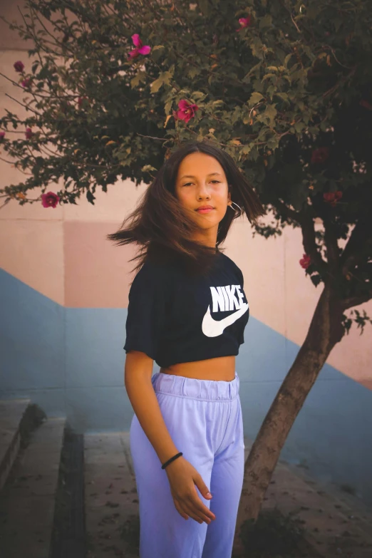 a woman standing in front of a tree, an album cover, by Niko Henrichon, trending on unsplash, graffiti, nike shirt, croptop, portrait of teen girl, 15081959 21121991 01012000 4k