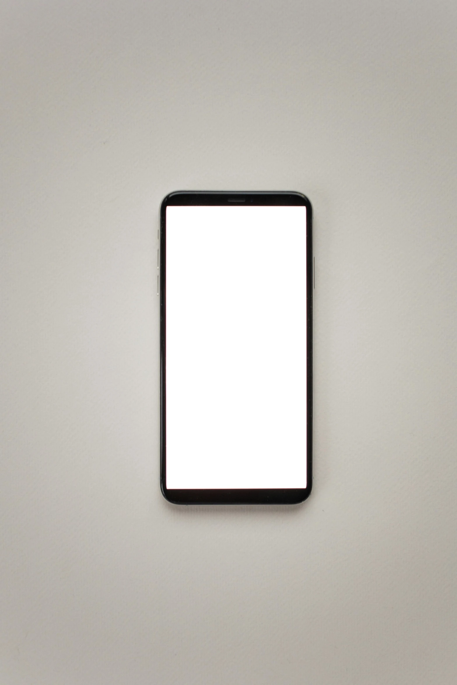 a cell phone sitting on top of a table, a picture, pexels, realism, solid light grey background, android phones, 2 0 5 6 x 2 0 5 6, black!!!!! background