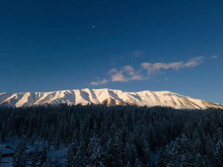 mountainside with snow on it and blue sky