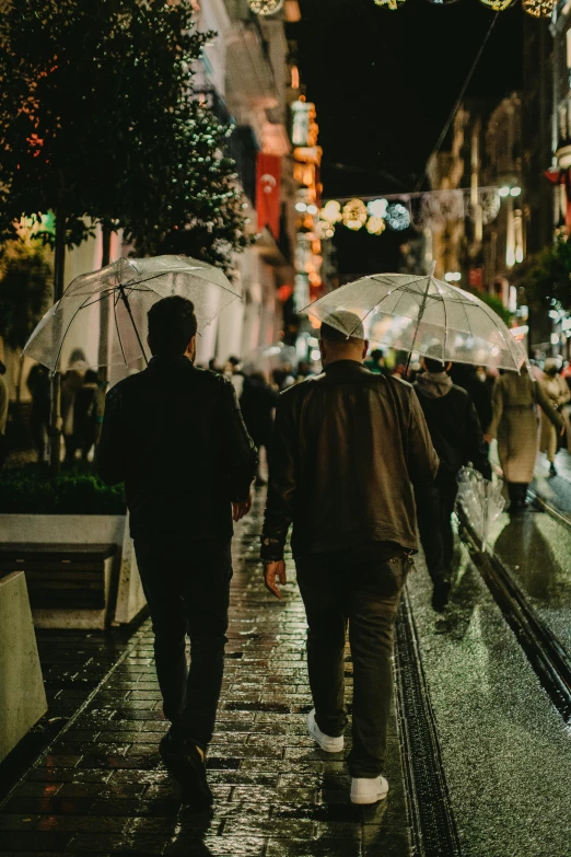 two people with umbrellas walking down the street