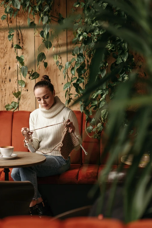 a woman sitting on a bench reading and having a coffee