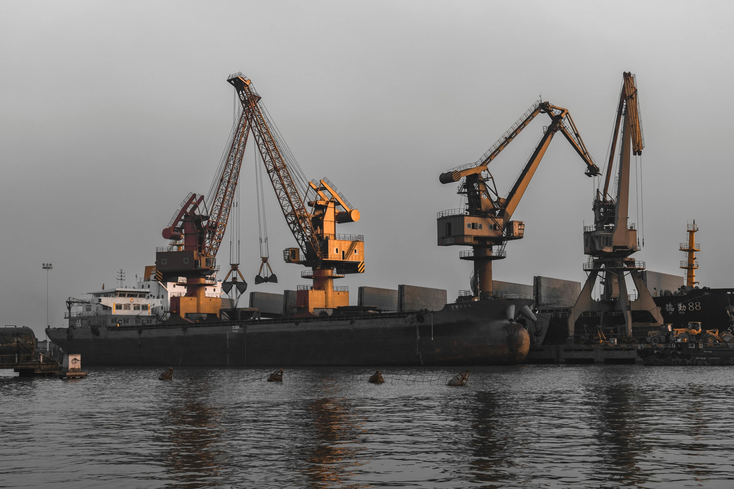 a large boat sitting on top of a body of water, pexels contest winner, constructivism, huge machine cranes, black, trading depots, grey