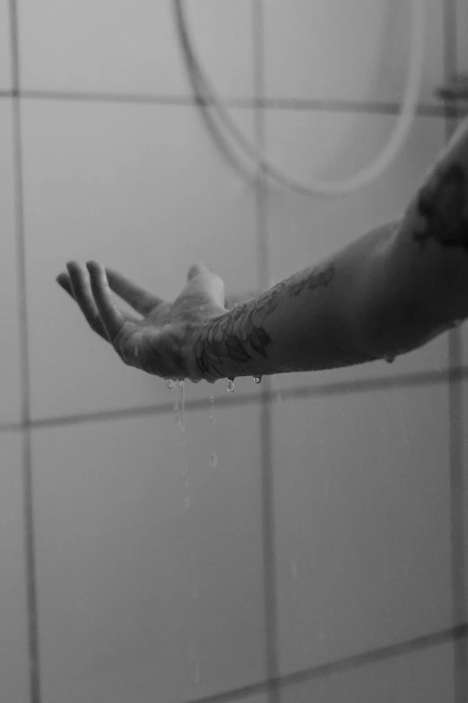 a black and white photo of a person washing their hands, a black and white photo, inspired by Elsa Bleda, unsplash, conceptual art, tattooed, showers, floating away, :: morning