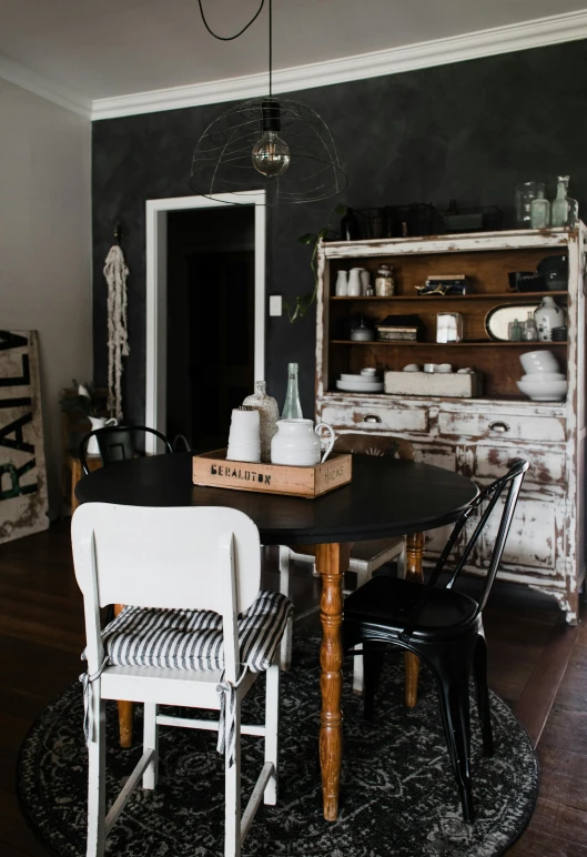 an antique table in the kitchen with vintage appliances and vintage cabinets