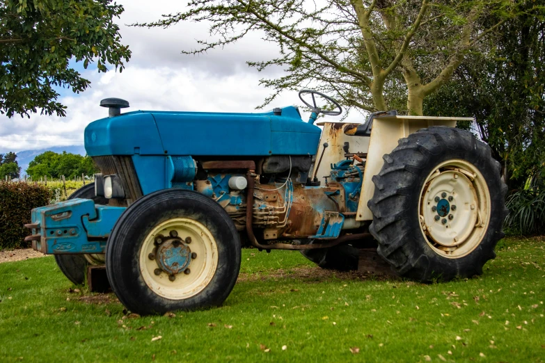 a blue tractor sitting on top of a lush green field, old school fpr, gordon onslow ford, museum quality photo, 4k-