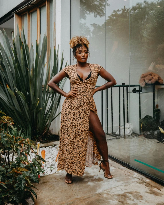 a woman in an animal print dress stands on a concrete slab