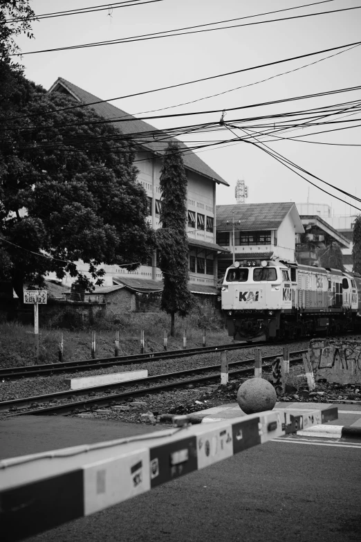 black and white po of train on tracks next to residential area