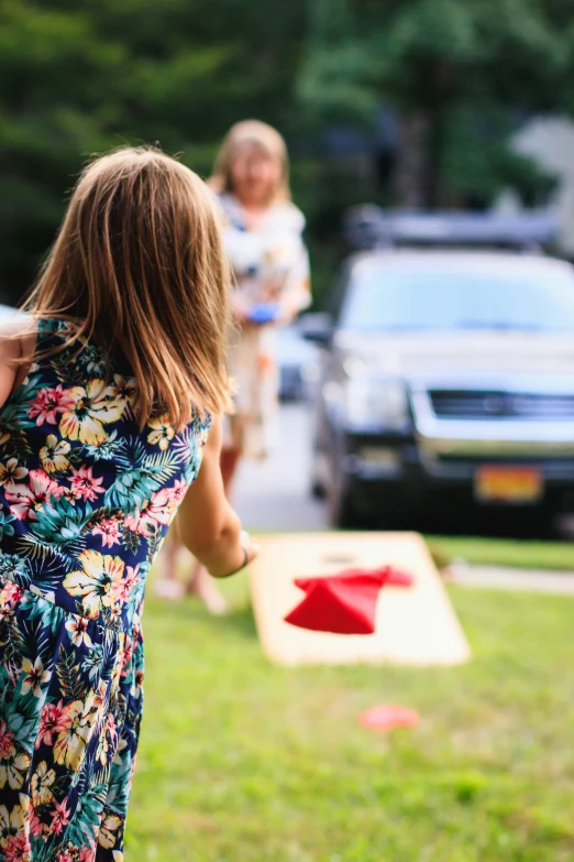 a little girl standing on top of a lush green field, by Julia Pishtar, pexels contest winner, cars, backyard wrestling, launching a straight ball, block party