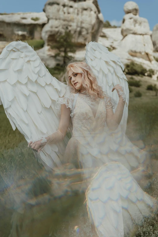 a woman in a white dress with angel wings, an album cover, inspired by Elsa Bleda, pexels contest winner, renaissance, sydney sweeney, white witch, cupid, on location