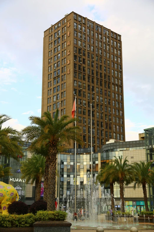 a large building has fountains with a flag on it