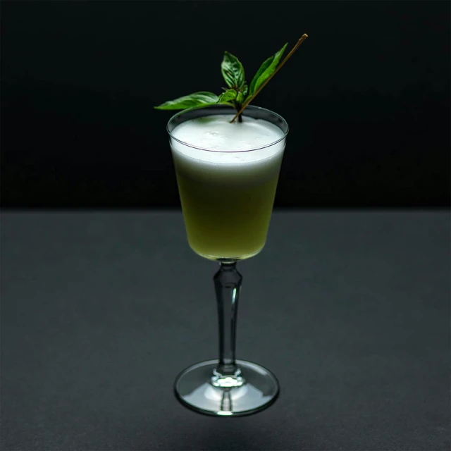 a glass filled with a drink sitting on top of a table, green and white, dipstick tail, jasmine, full product shot