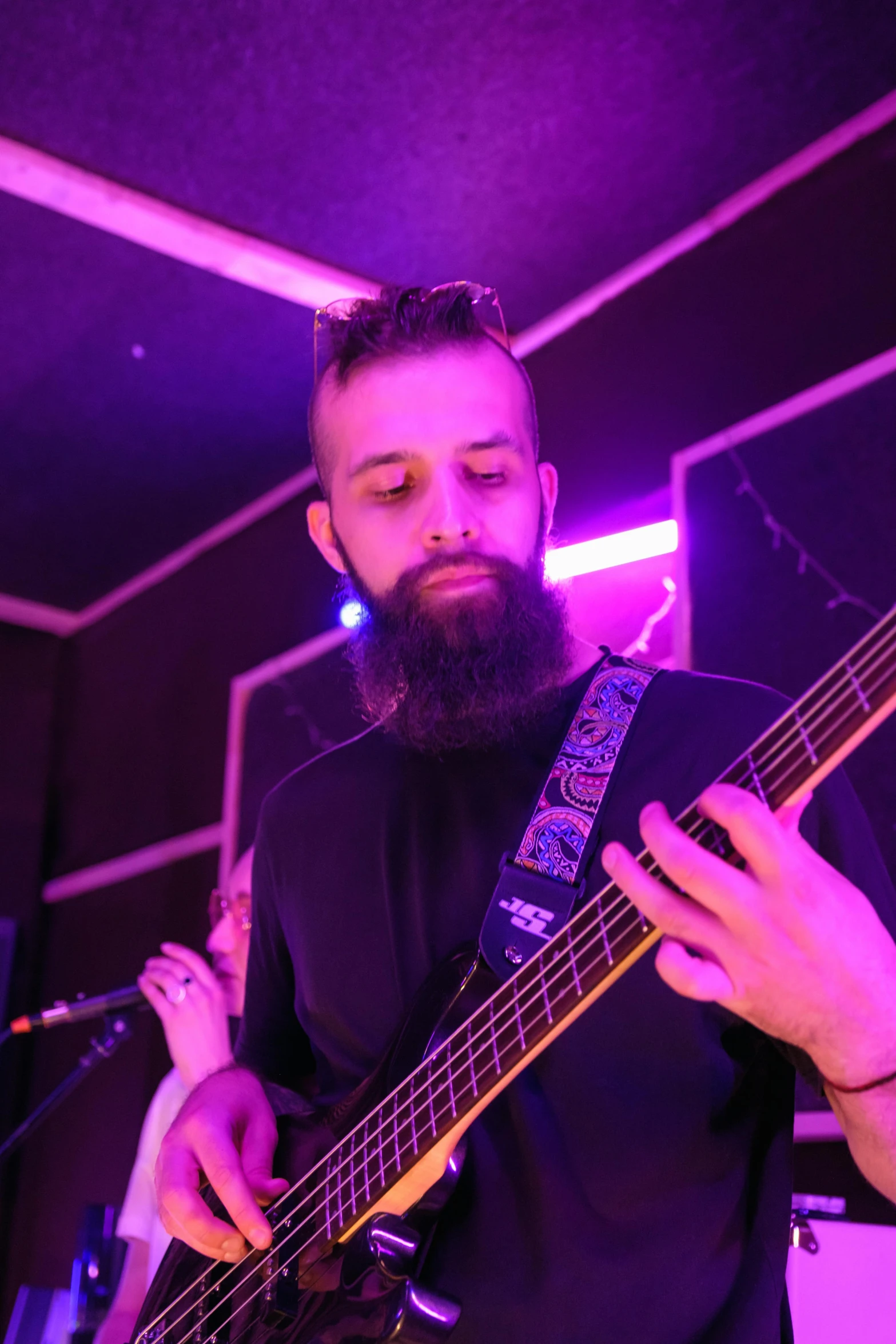 a man with a beard playing a bass guitar, reddit, antipodeans, purple - tinted, profile image, wearing spiky, looking towards camera