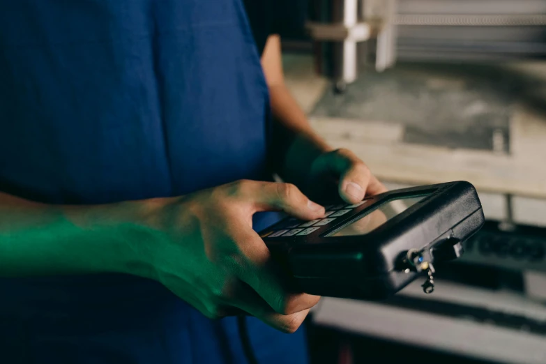 a close up of a person holding a remote control, in a workshop, profile image, mechanical, holding a clipboard