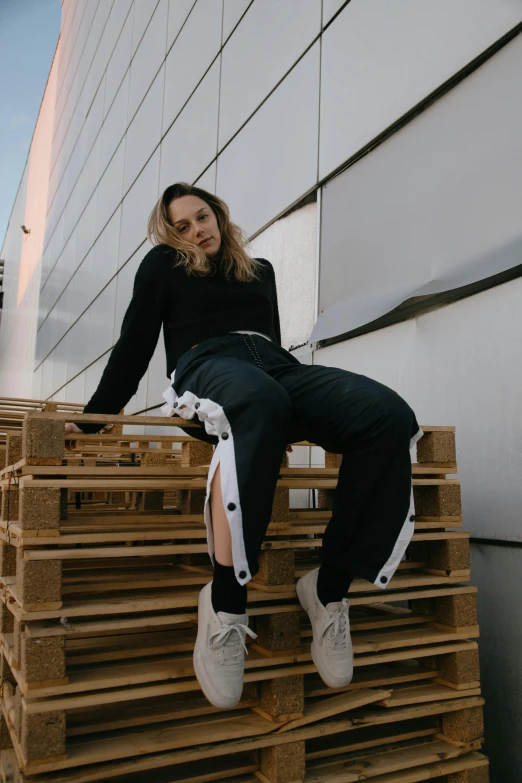 a woman sitting on a stack of wooden pallets, by Matija Jama, trending on pexels, renaissance, baggy pants, techwear fashion, profile pic, off white