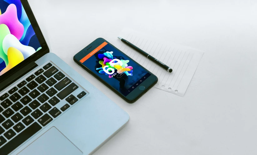 a laptop computer sitting on top of a desk next to a cell phone, by Android Jones, trending on pexels, neon geometric inks, orange and blue colors, thumbnail, overview