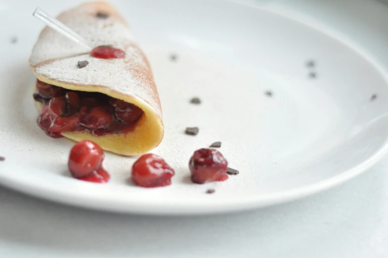 a crepe with jelly, cherries and powdered sugar