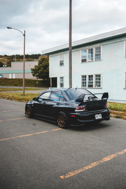 a black car parked in front of a building, by Chris Rallis, unsplash, japanese drift car, low quality photo, sittin, craigslist photo