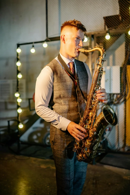 a man in a vest is playing the saxophone