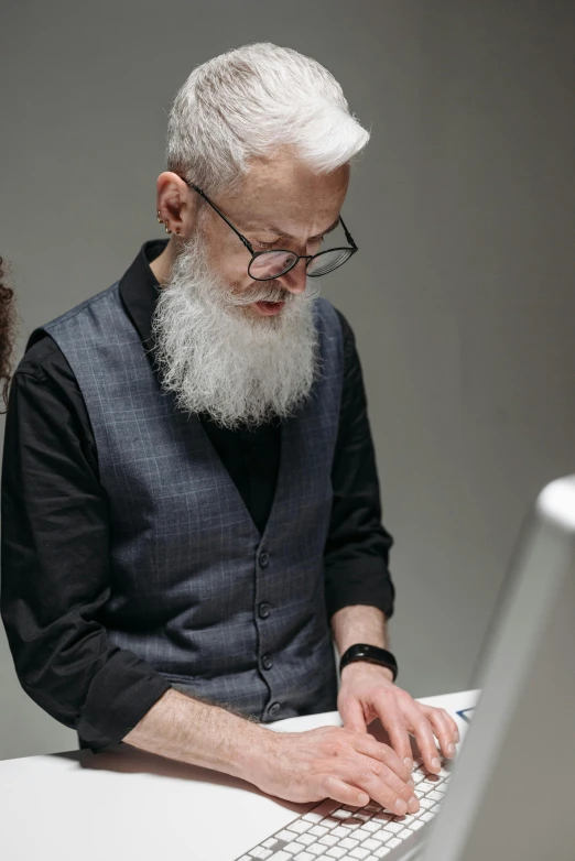 a man sitting in front of a laptop computer, by Paul Bird, trending on unsplash, very long white beard and hair, two skinny old people, museum curator, silver ponytail hair