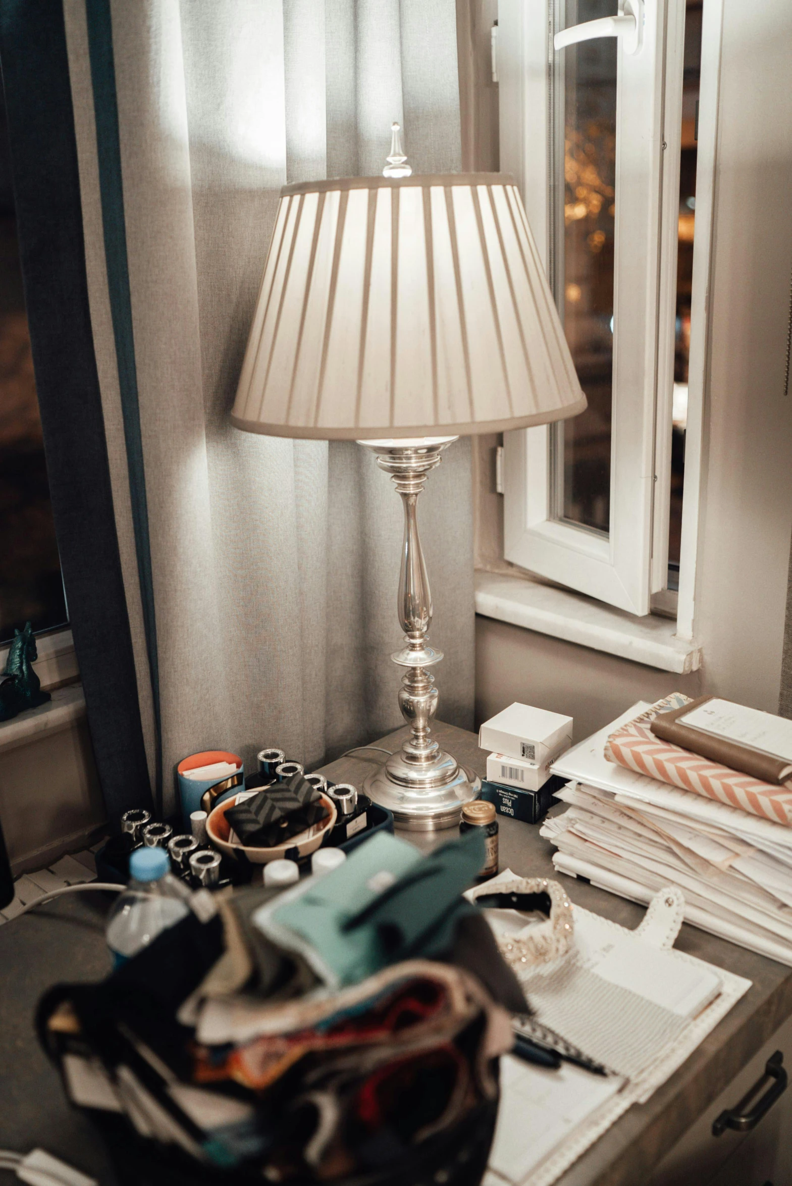 a desk with a lamp on it and other items sitting next to it