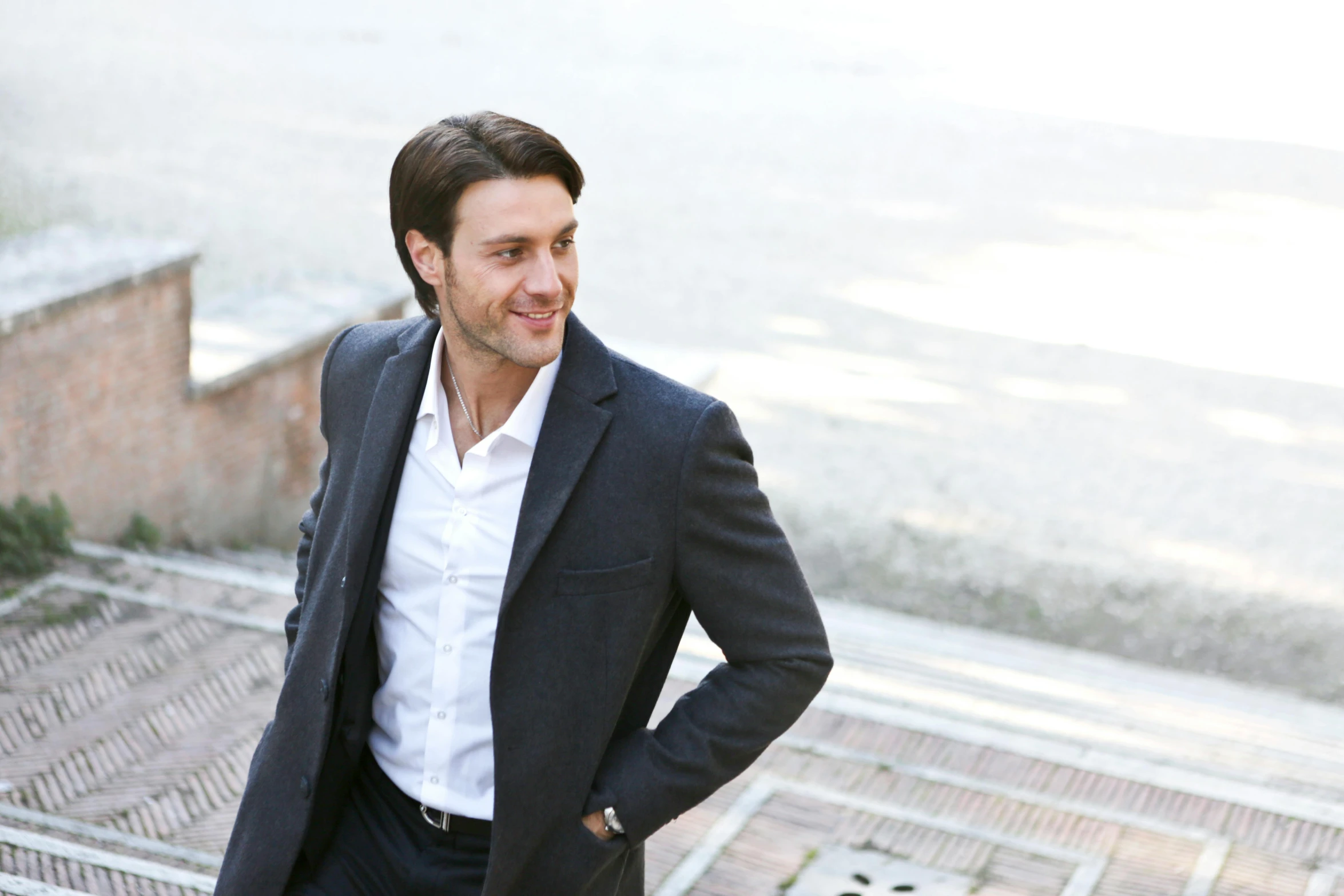 a man in a suit standing on a set of stairs, inspired by Ramon Pichot, pexels contest winner, renaissance, smiling male, antony starr, urban surroundings, promotional image