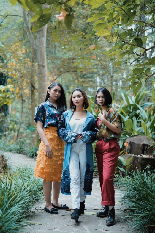 three women standing next to each other on a path, a portrait, unsplash, sumatraism, foliage clothing, concert, kuntilanak on tree, vintage vibe